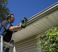 Photo of a skilled worker repairing residential gutters
